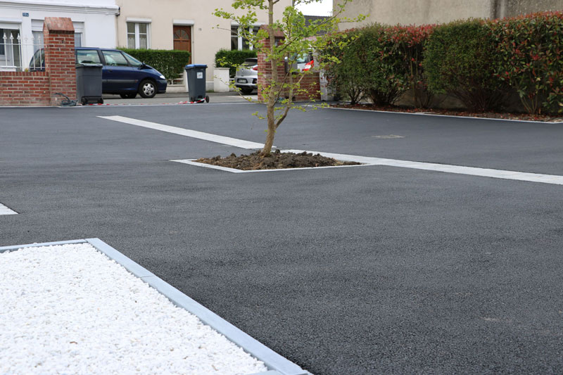 Cour extérieure en enrobé avec trottoir en dalles