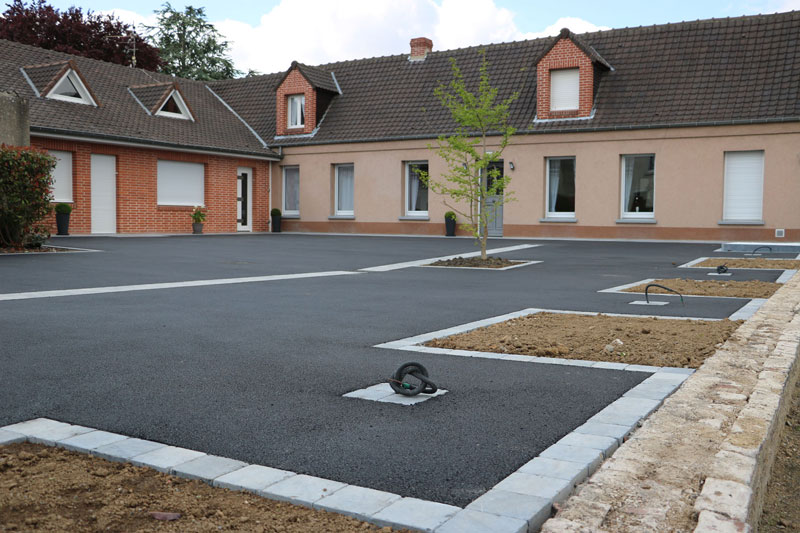 Cour extérieure en enrobé avec trottoir en dalles