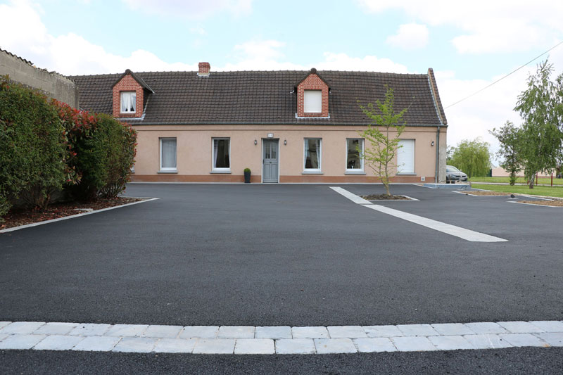 Cour extérieure en enrobé avec trottoir en dalles